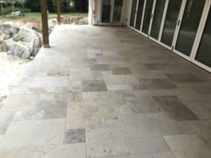 Stone-look outdoor tiles installed on a covered residential patio