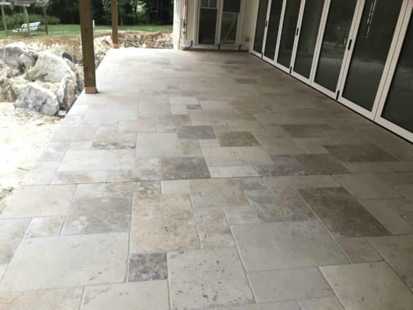 Stone-look outdoor tiles installed on a covered residential patio