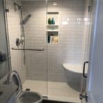 This image features a curbless shower with seating inside of the shower space.
