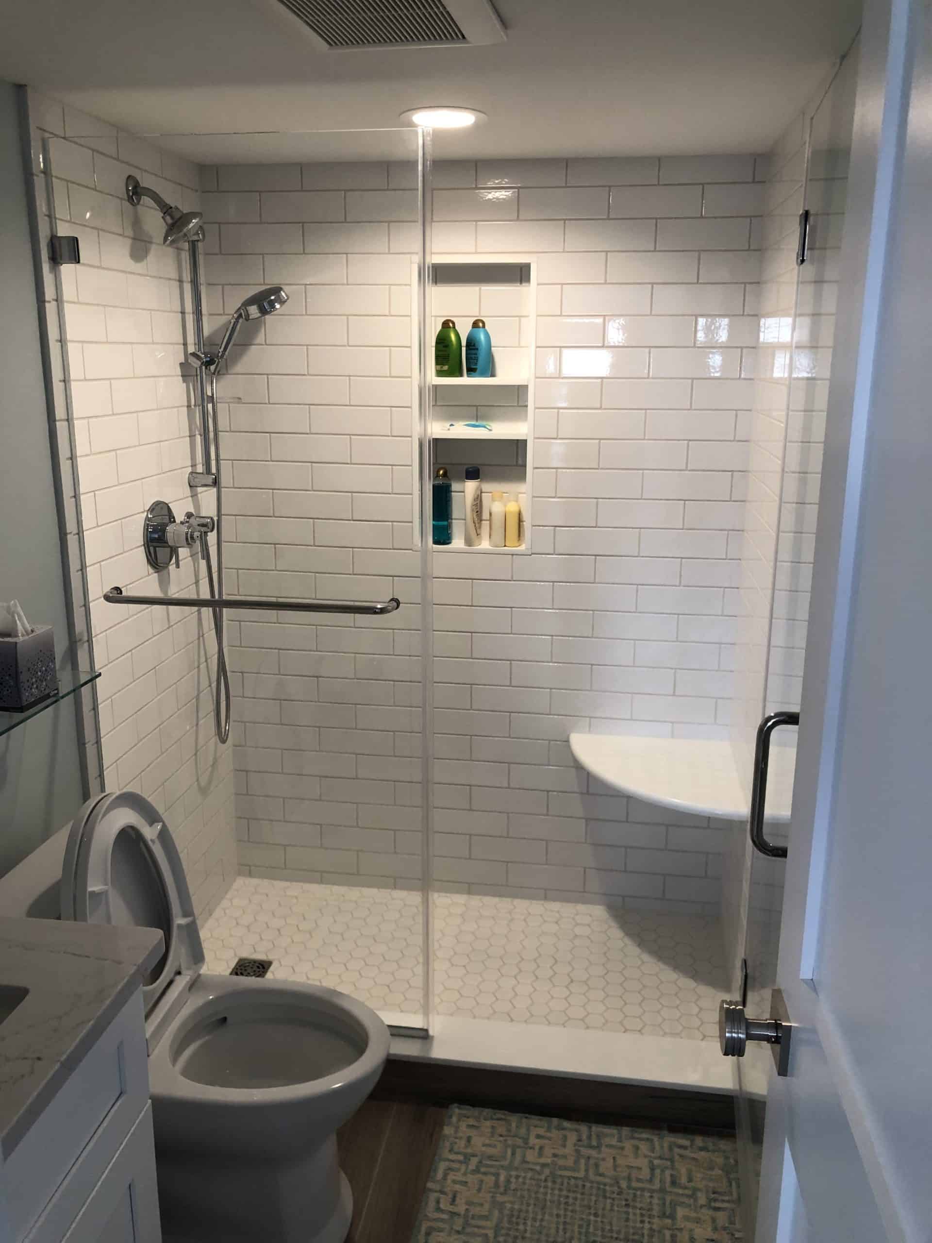 This image features a curbless shower with seating inside of the shower space.