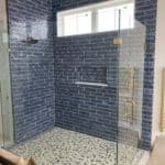 This image features a walk-in shower with grey tiling.