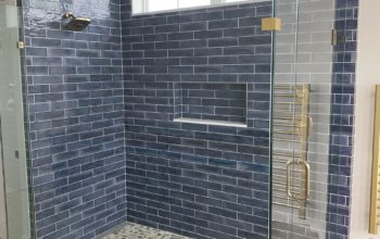 This image features a walk-in shower with grey tiling.