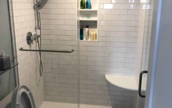 This image features a curbless shower with seating inside of the shower space.