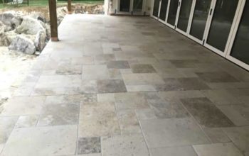 Stone-look outdoor tiles installed on a covered residential patio